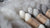Undyed skeins of Garthenor Organic’s Fallow yarn in three shades — off-white (Rest), grey (Return), and marled (Interval) — nestled in soft fleece.